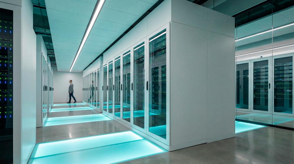 Элегантные матово-белые серверные стойки в высокотехнологичном дата-центре с мягкой циановой подсветкой